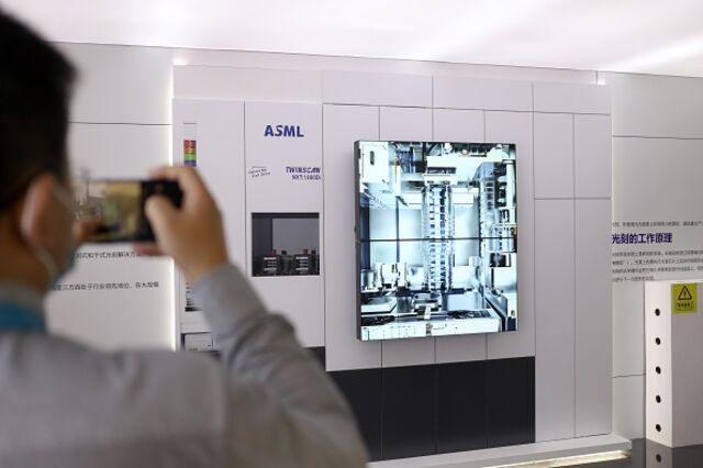 Посетитель фотографирует устройство для коррекции положения маски ASML на третьей Китайской международной импортной выставке в ноябре 2020 года в Шанхае.